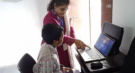 Teacher teaching student on laptop
